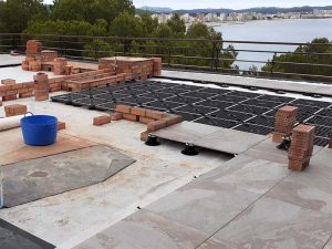 Col·locació de paviment flotant que combina paviment porcellànic i gespa artificial
